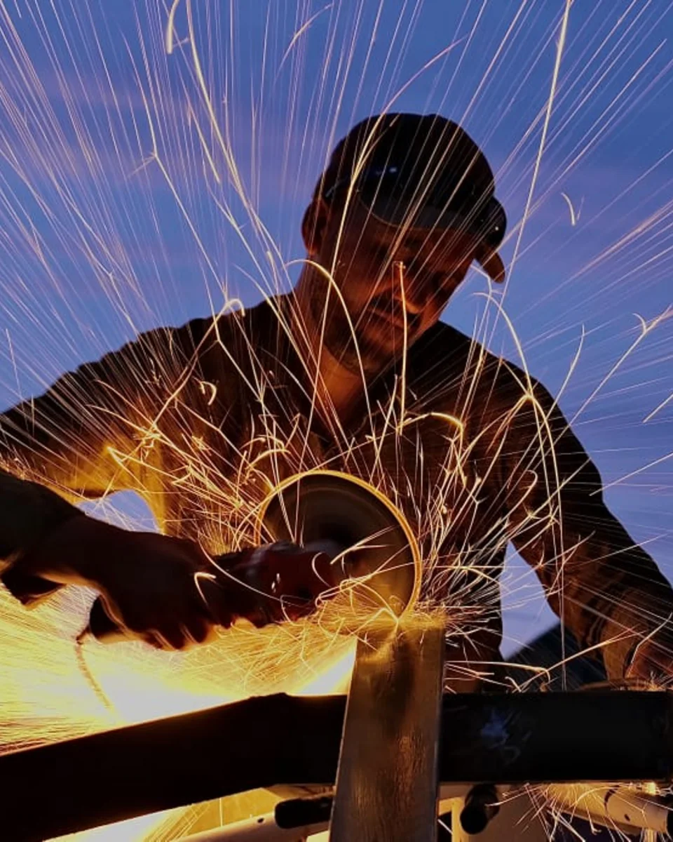 Soudeur d'Aluminium Marrakech découpant un profilé métallique, gerbe d'étincelles