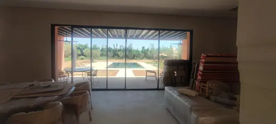 Baie vitrée coulissante en aluminium ouvrant un salon sur la piscine