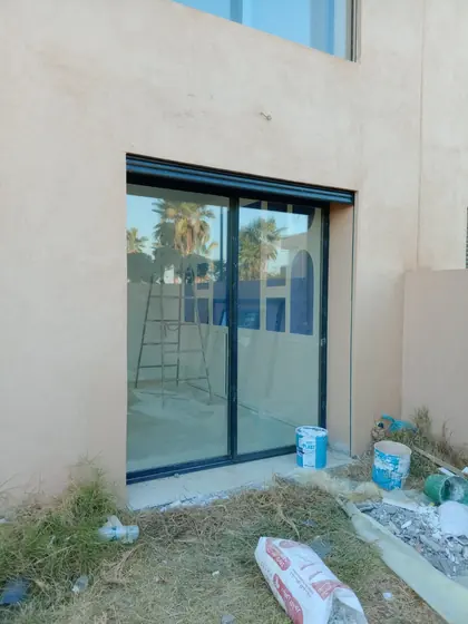 Baie vitrée coulissante aluminium posée en façade d’une villa en construction