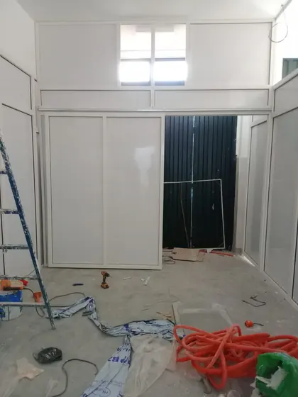 Ensemble de cloisons aluminium laquées blanc et porte vitrée en cours de pose