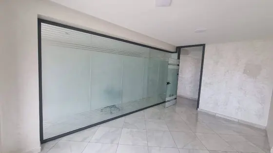 Cloison vitrée de grande portée à cadre aluminium noir dans un local professionnel