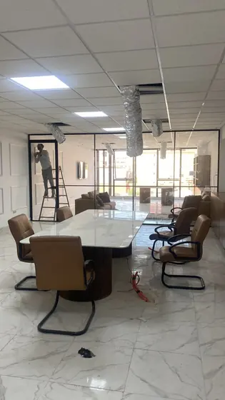 Salle de réunion fermée par une cloison vitrée à cadre aluminium