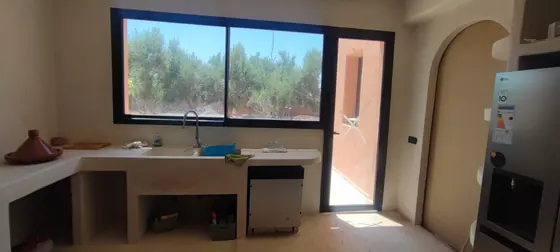 Fenêtre coulissante en aluminium noir ouvrant une cuisine sur le jardin