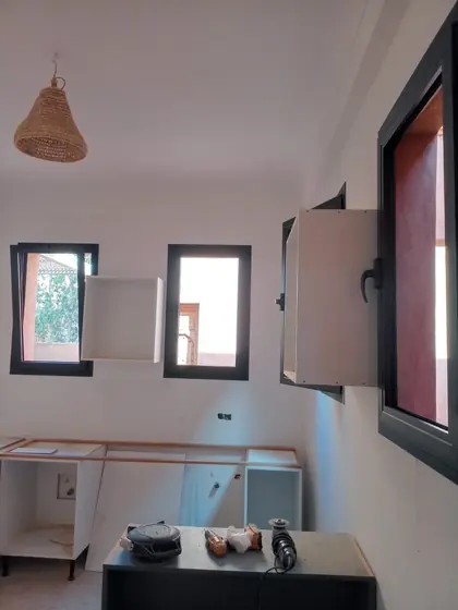 Fenêtres aluminium noires et habillage mural dans une chambre en cours de finition