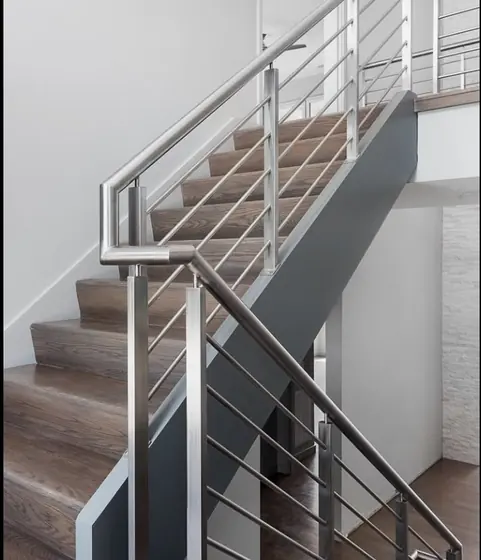 Garde-corps en inox à lisses horizontales le long d’un escalier en bois