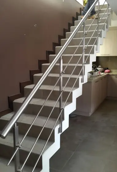 Garde-corps inox à lisses le long d’un escalier ouvert sur la cuisine