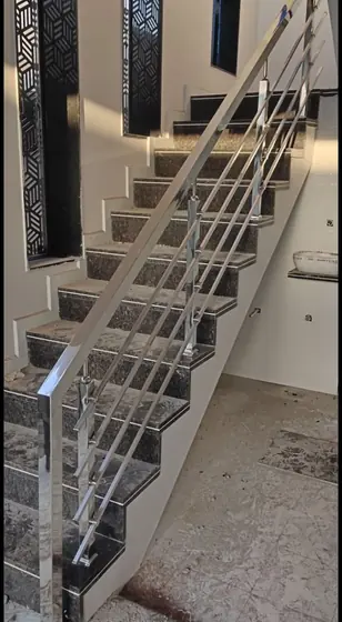 Rampe et garde-corps inox d’un escalier en pierre, sous un moucharabieh