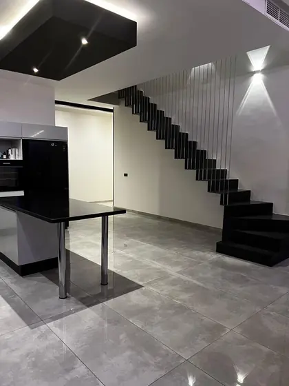 Escalier suspendu à limon métallique noir et garde-corps à barreaudage vertical