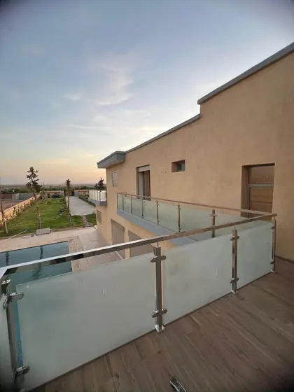 Garde-corps vitré d’une terrasse de villa au coucher du soleil