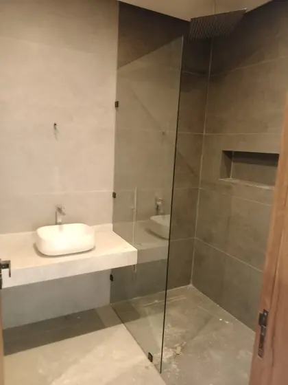 Douche à l’italienne fermée par une paroi de verre, salle d’eau en pierre