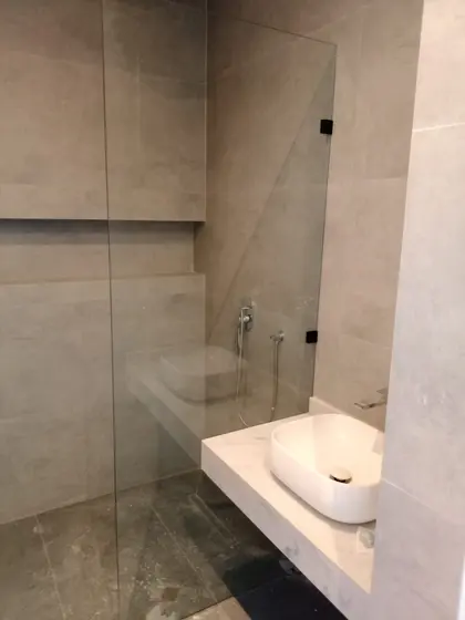 Paroi de douche à l’italienne en verre et plan vasque en pierre