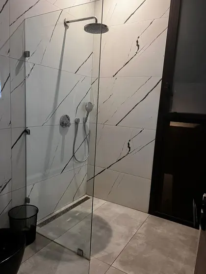 Paroi de douche fixe en verre devant un marbre à veines noires