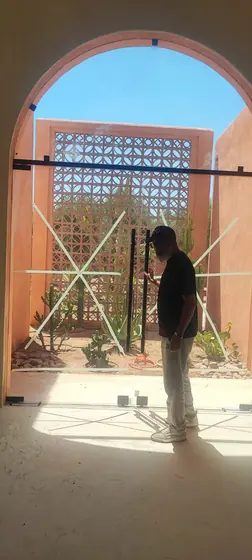 Pose d’une porte vitrée sur mesure sous une arche en pisé