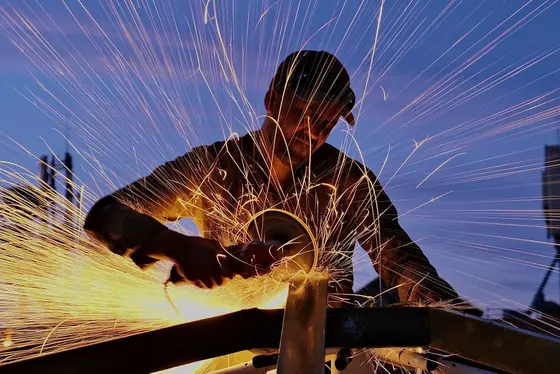 Soudeur d’Aluminium Marrakech en action, gerbe d’étincelles sur fond de ciel