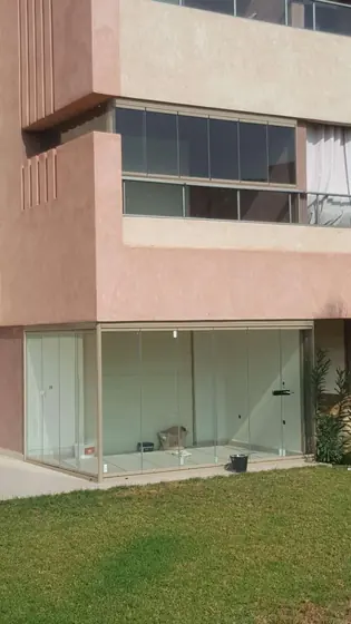 Véranda vitrée en rez-de-jardin d’une villa à la façade rose de Marrakech