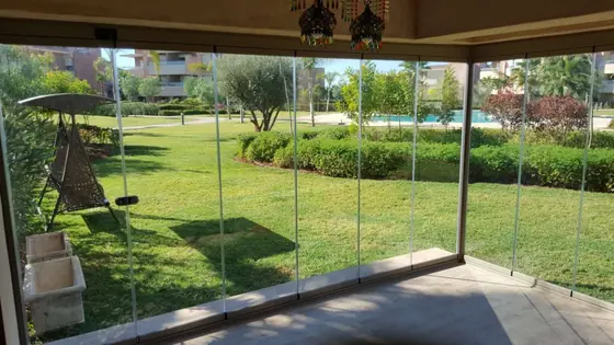 Véranda vitrée à montants fins ouvrant sur un parc arboré